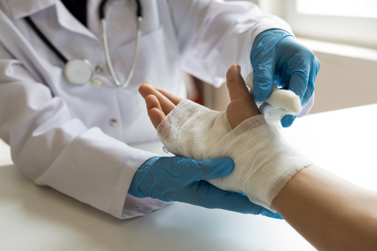 Clinician wrapping a bandage around a patient's injured hand