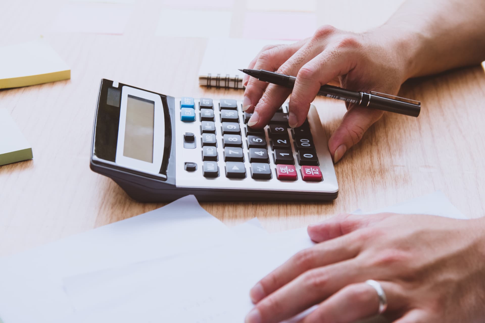 A veteran using a calculator and pen to work out a combined VA disability percentage