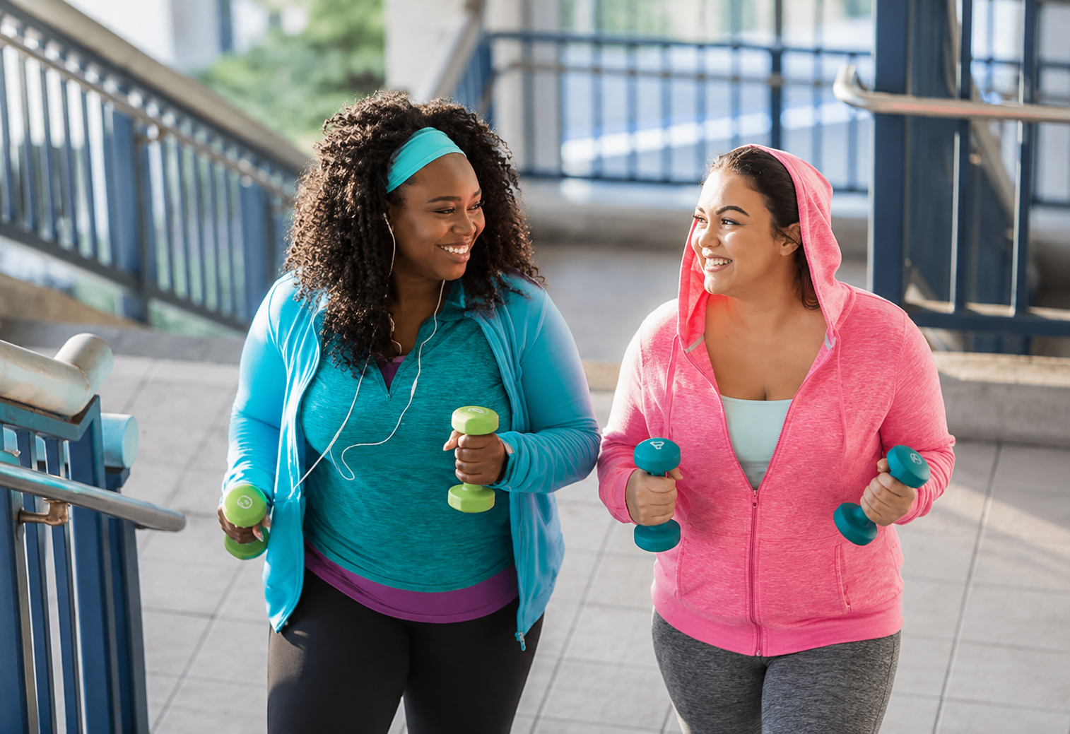 Two women veterans walking with hand weights while exercising together